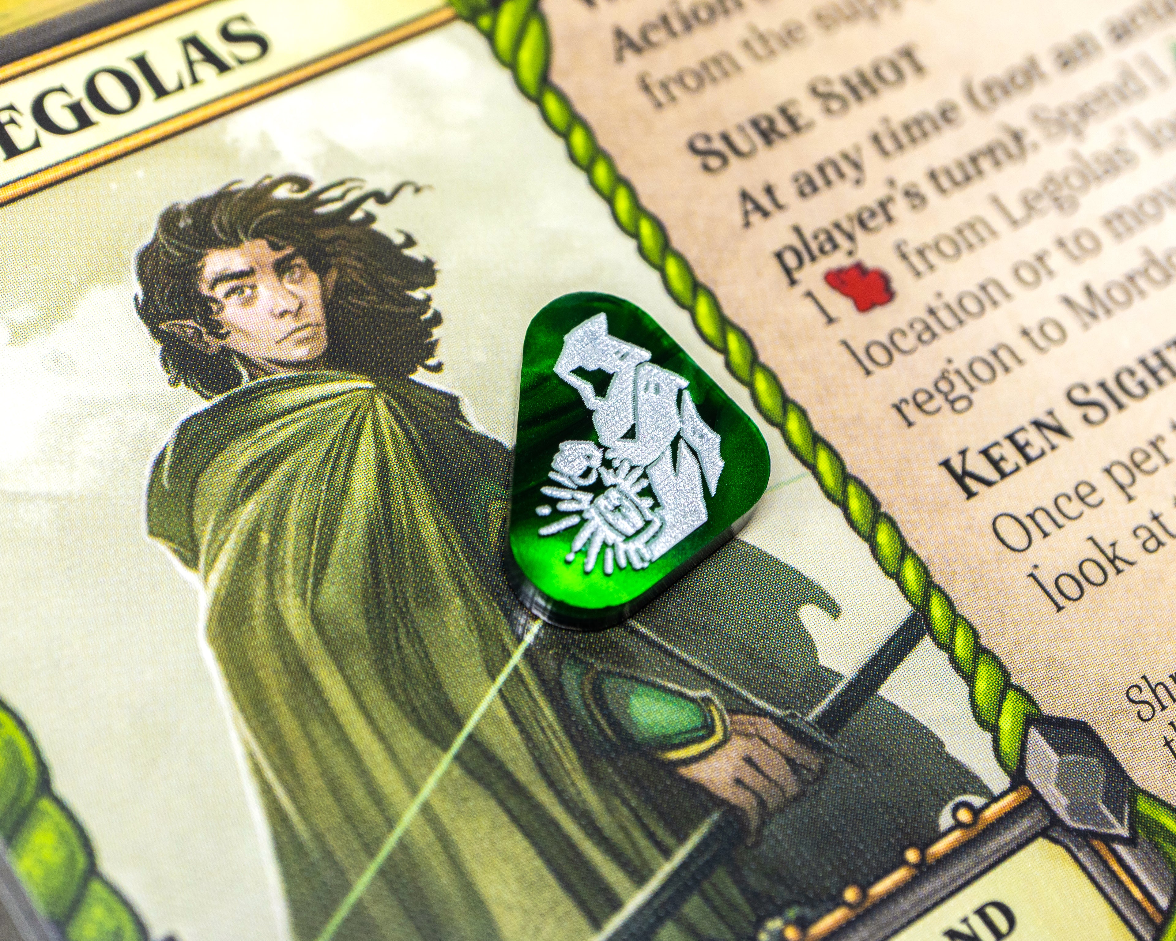 A hooded figure with a lantern painted white on green marble acrylic represents Stealth. 